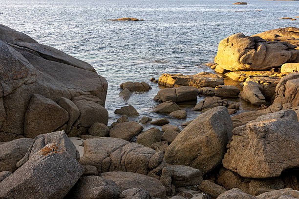 istock A rocky shoreline with a large rock in the foreground 2223039073