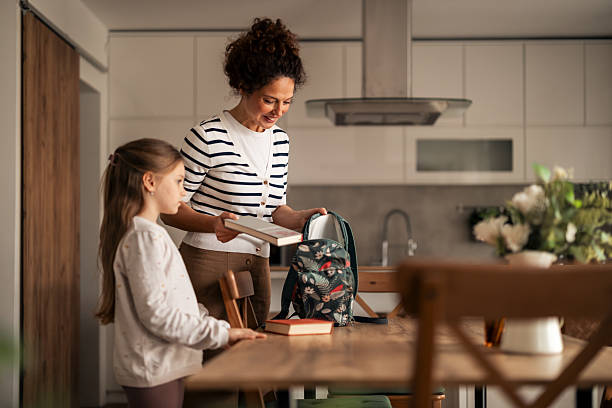 istock Mother Helping Daughter Pack Books in Backpack for School 2223041350