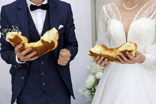 istock Newlyweds break bread in half. Wedding celebration traditions. 2223041724