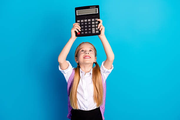 istock Excited schoolgirl with calculator celebrating learning against a blue background displaying achievement and joy 2223045721