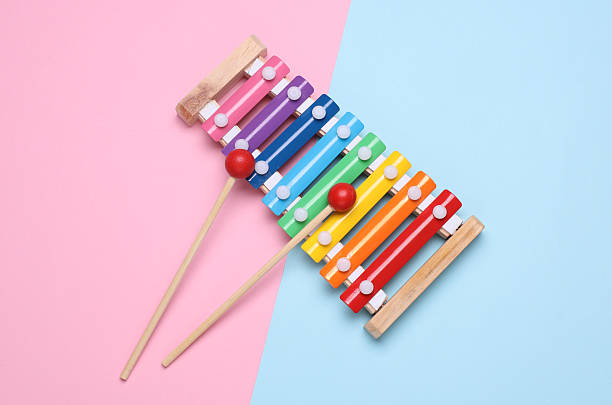 Children's multi-colored xylophone on a blue and pink background