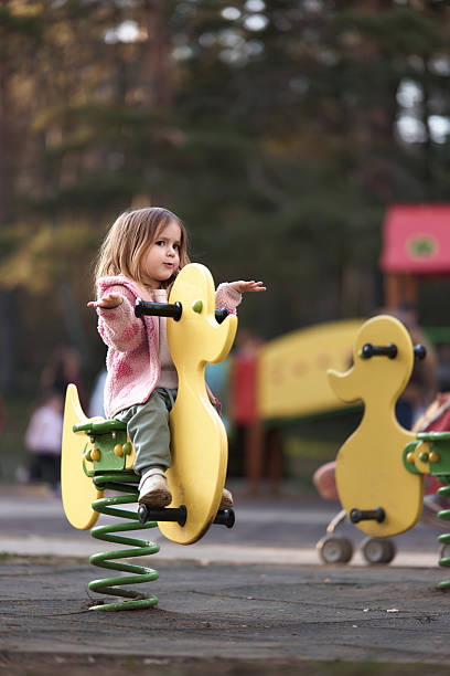 istock Little girl sits on a playground spring rider. 2223050098