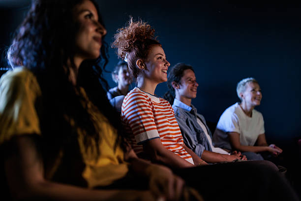 Audience seitting in a movie theater, watching the film with great excitement and focused attention.