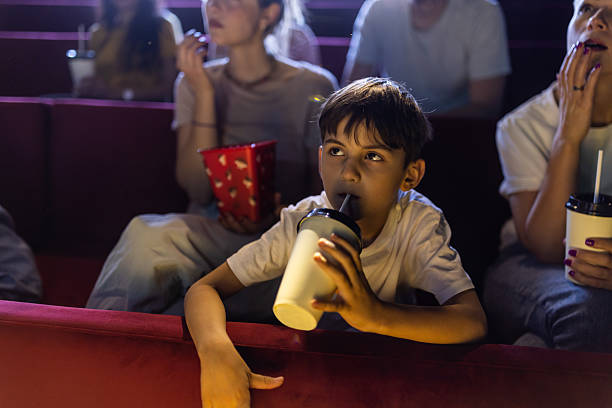 istock Little boy enjoying a drink in cinema 2223052207