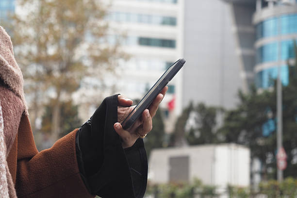 Woman using smartphone outdoors in a modern urban setting