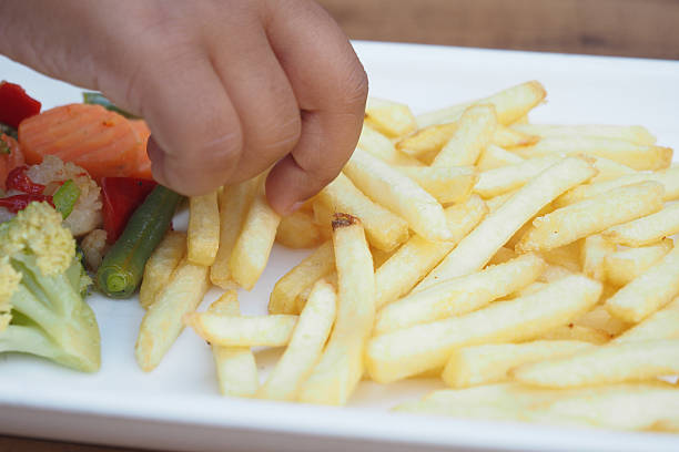 istock Child enjoying crispy fries with fresh vegetables on a plate 2223053929