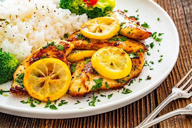 istock Lemon chicken escalopes with rice on wooden table 2223055854