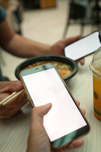 istock Couple with smart phones in a cafe 2223061929