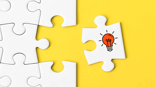 istock Final puzzle piece with red light bulb symbol on yellow background – concept for idea or solution 2223063225