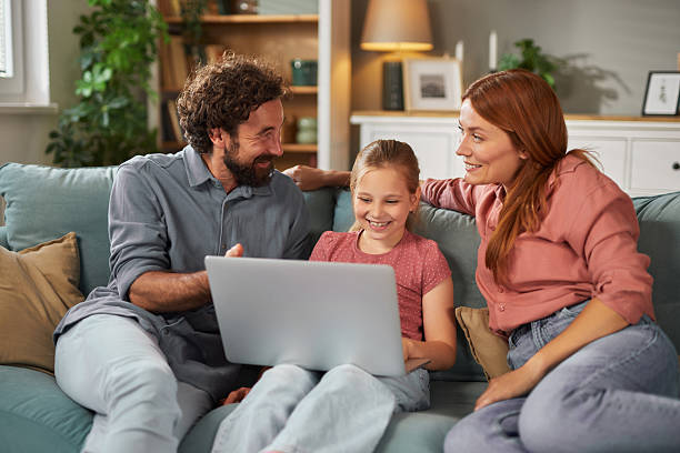 istock Family enjoying time together using laptop on the sofa at home 2223064175