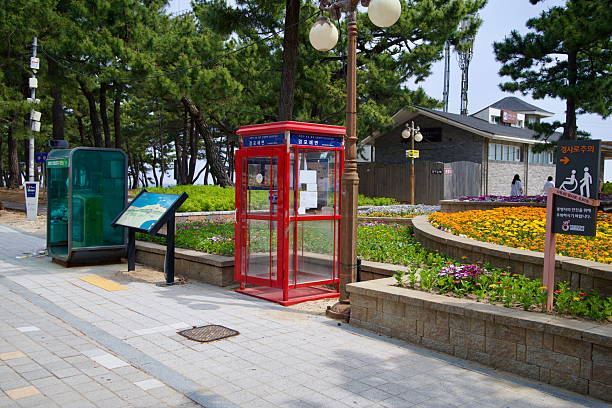 Gangneung, South Korea - June 1st 2025: A red phone booth-style certification center at Gyeongpodae Beach lets cyclists on the Gangwon Bike Path stamp their official bike passports.