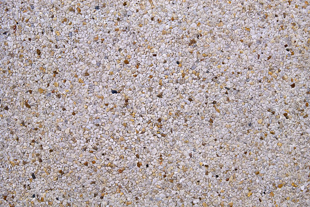 istock Light gray exposed aggregate concrete in closeup - pattern with some brown stones 2223065843