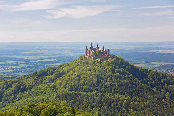 Aerial view of famous Hohenzollern Castle in thick fog and majestic light, Swabian Alps, Baden-Wurttemberg, Germany