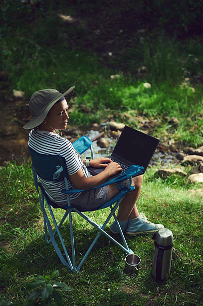 istock Woman Working Outdoors on Laptop at a Remote Nature Location 2223069944