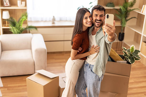 istock Happy couple taking selfie in new apartment while moving in 2223070925