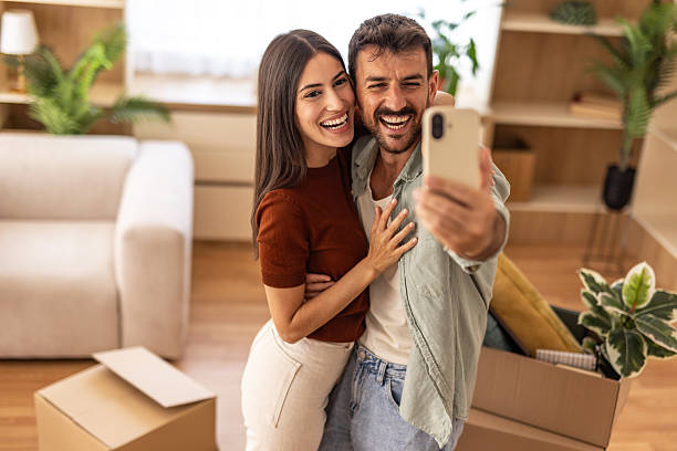istock Happy couple taking a selfie in their new home while unpacking 2223070926