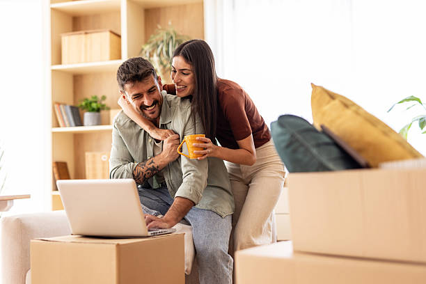 istock Happy couple using laptop and drinking coffee in new home 2223072018