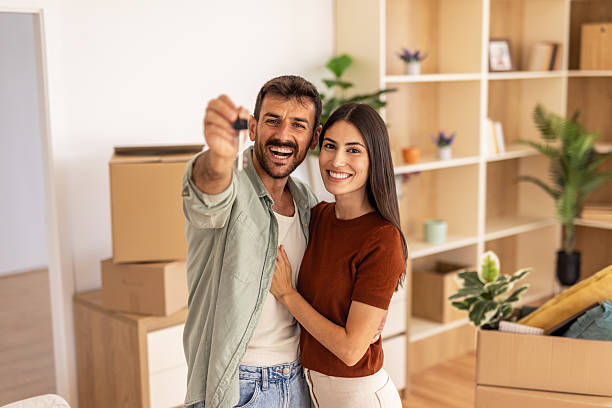 istock Happy couple showing new house keys while moving in 2223072236