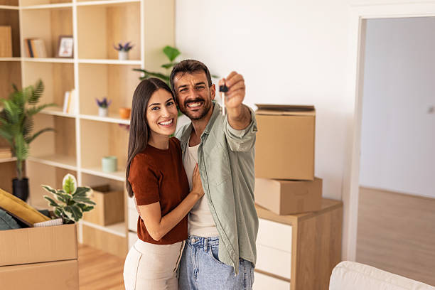 istock Happy couple showing new house keys while embracing 2223072304