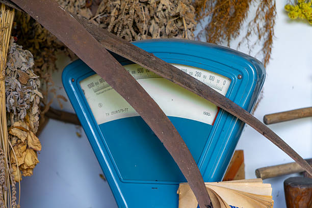 vintage blue analog scale surrounded by dried herbs, paper, and metal tools. Retro composition, perfect for themes related to trade, craftsmanship, and traditional lifestyle.