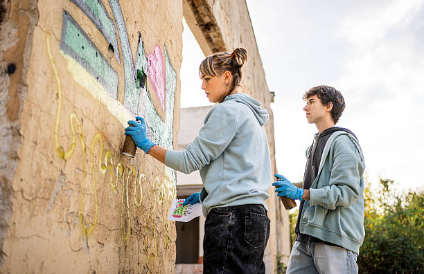 istock Young artists painting graffiti on a derelict building wall 2223076263
