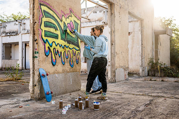 istock Young artists painting graffiti on a wall in abandoned building 2223076404