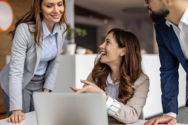 istock Business team smiling and discussing work on laptop in office 2223076522