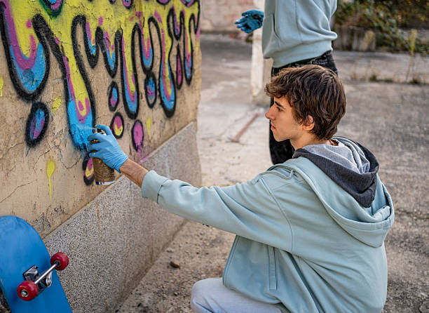 istock Young graffiti artists spray painting a wall with aerosol cans 2223076644