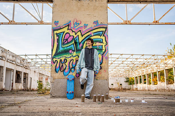 istock Young graffiti artist posing with his skateboard and spray cans 2223076875