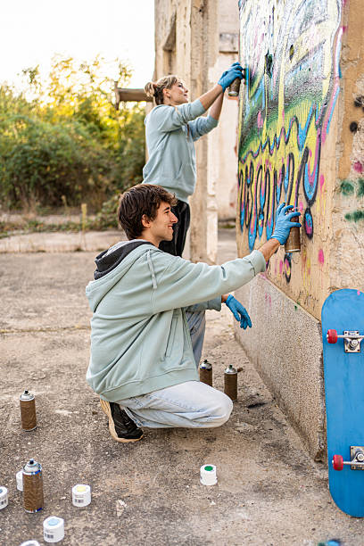 istock Young artists painting graffiti on a derelict building wall 2223076932