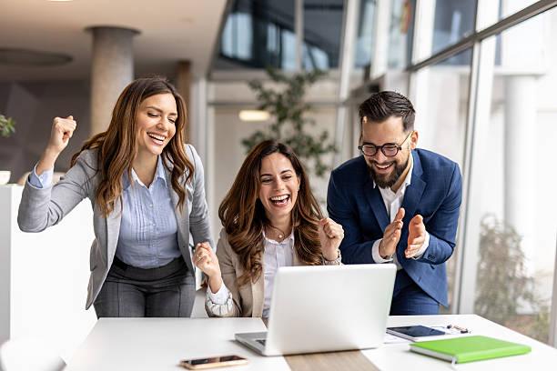 istock Business team celebrating success while looking at laptop in office 2223077812