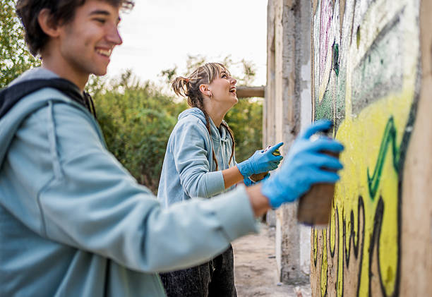 istock Two young graffiti artists painting on a wall and having fun 2223078041