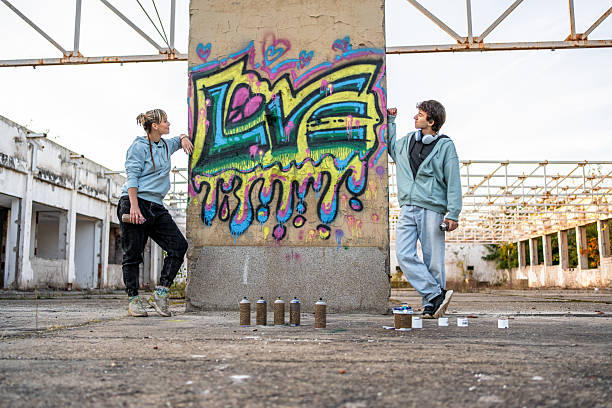 istock Young graffiti artists posing with their artwork in abandoned building 2223078712