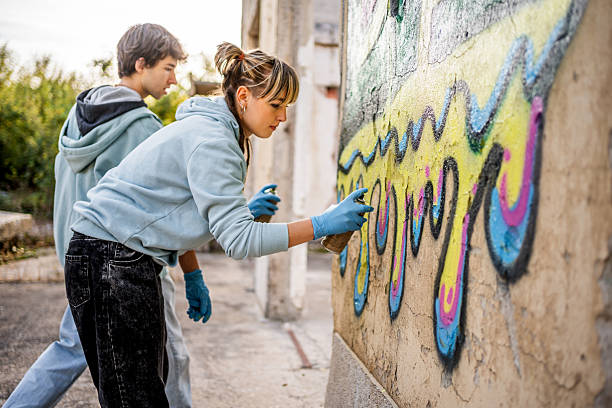 istock Young artists painting graffiti on a wall 2223078729