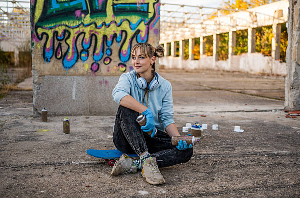 istock Young female graffiti artist taking break on skateboard 2223078768