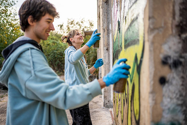 istock Two young graffiti artists painting a wall with spray cans 2223078820