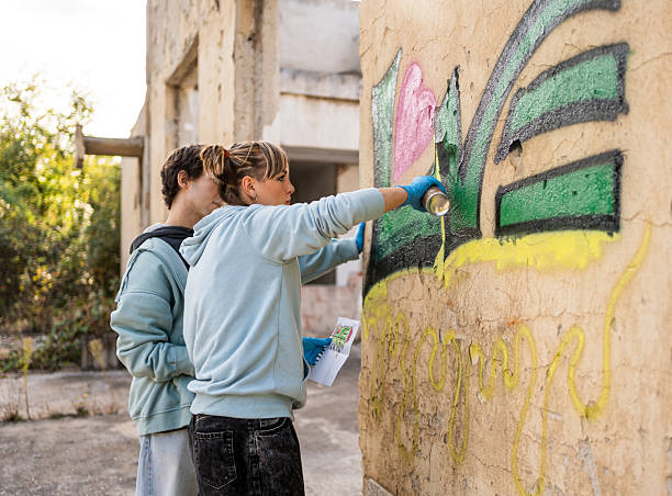 istock Two young graffiti artists painting on a ruined wall 2223078847
