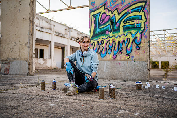 istock Young female graffiti artist taking break in abandoned building 2223078900