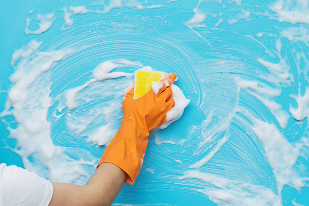 istock Woman hand cleaning blue wall with sponge 2223084399