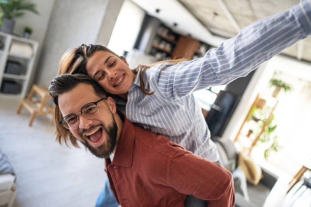istock Young couple piggybacking and having fun at home 2223084502