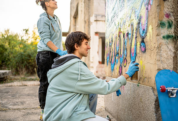 istock Two young artists painting graffiti on a wall 2223085608
