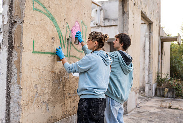 istock Two young artists painting graffiti on a derelict building wall 2223085852
