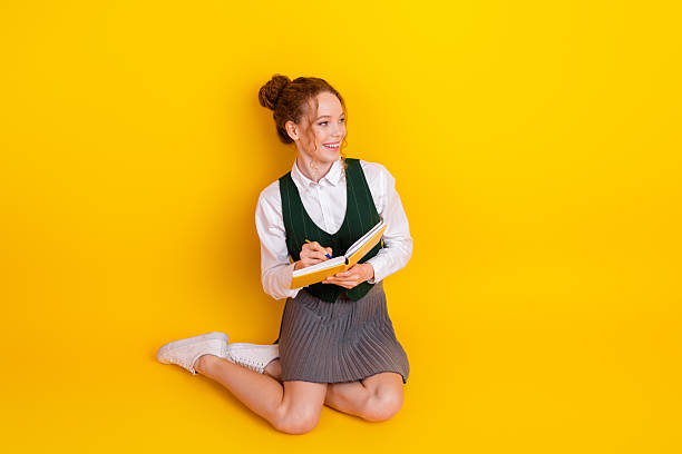 istock Young student on a bright yellow background holding a book while expressing joy and an academic enthusiasm 2223086967