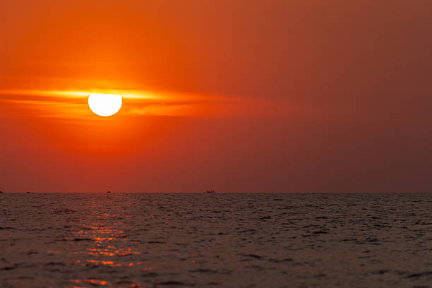 The sun is setting on tropic island over by horizon.
