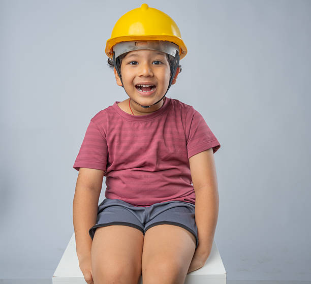 istock Happy boy in headwear sitting on white background 2223090675