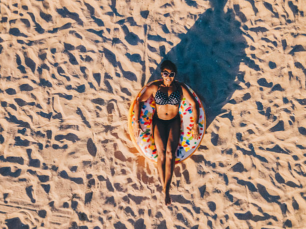 istock Relaxing woman sunbathing on a sandy beach from above 2223093113