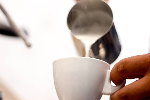 istock Barista pouring steamed milk into ceramic cup for coffee preparation 2223093240