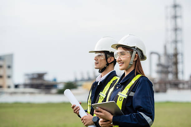 istock Engineering Team Looking Towards the Future with a Shared Vision. Two people wearing safety gear and holding papers 2223093269