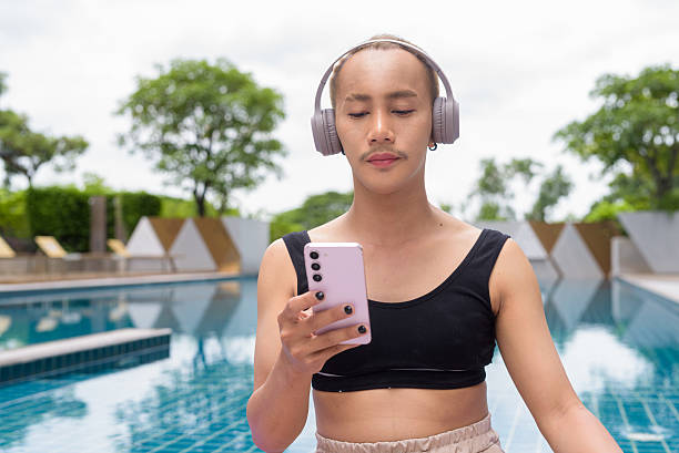 istock Non-binary person exercising in poolside doing yoga and wearing sport bra 2223093531