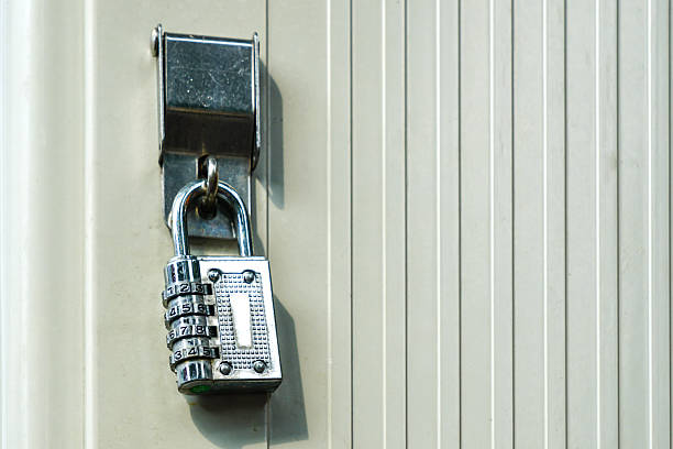 Close-up on a padlock on an old stainless steel door.